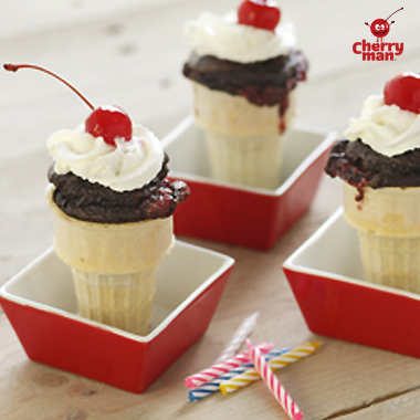 Chocolate cherry cake served in ice cream cones with cherry on top. 