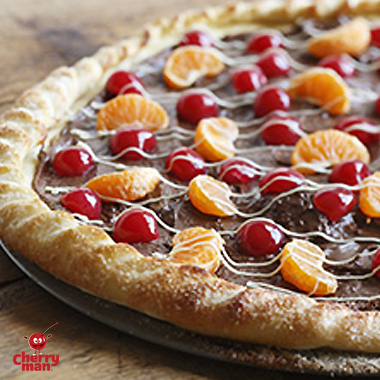 Dessert party pizza with golden brown crust, chocolate, cherries and mandarin orange slices.