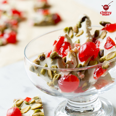 White chocolate cherry pistachio bark served in small snack bowl. 
