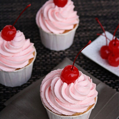 Cherry temple cupcakes with fluffy pink frosting.