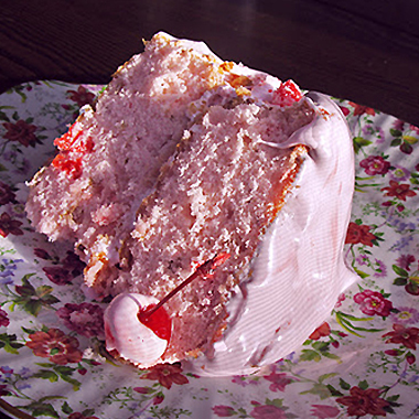 Single piece of maraschino cherry cake with cherry frosting