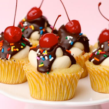 Fun banana split cupcakes with sprinkles and cherry on top.