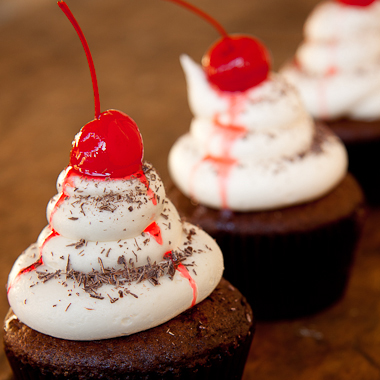 Black forest cupcakes with cherry on top and chocolate sprinkles.