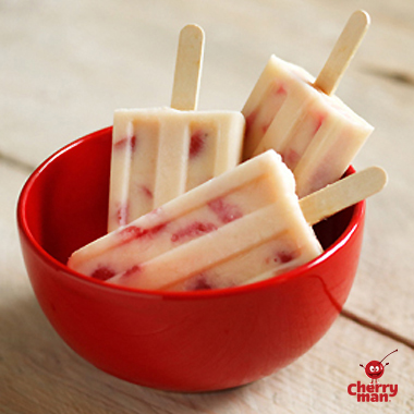 Light and creamy homemade cherry popsicles in red bowl