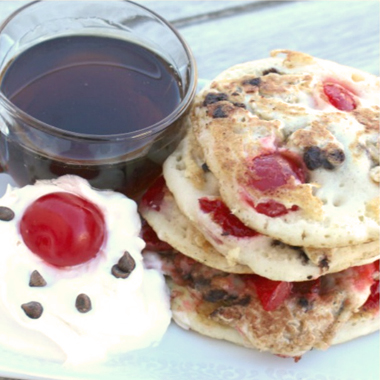 A stack of chocolate cherry cookies served with cold milk. 